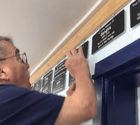 Memorial Plaque being hung by volunteer Rod Vetter